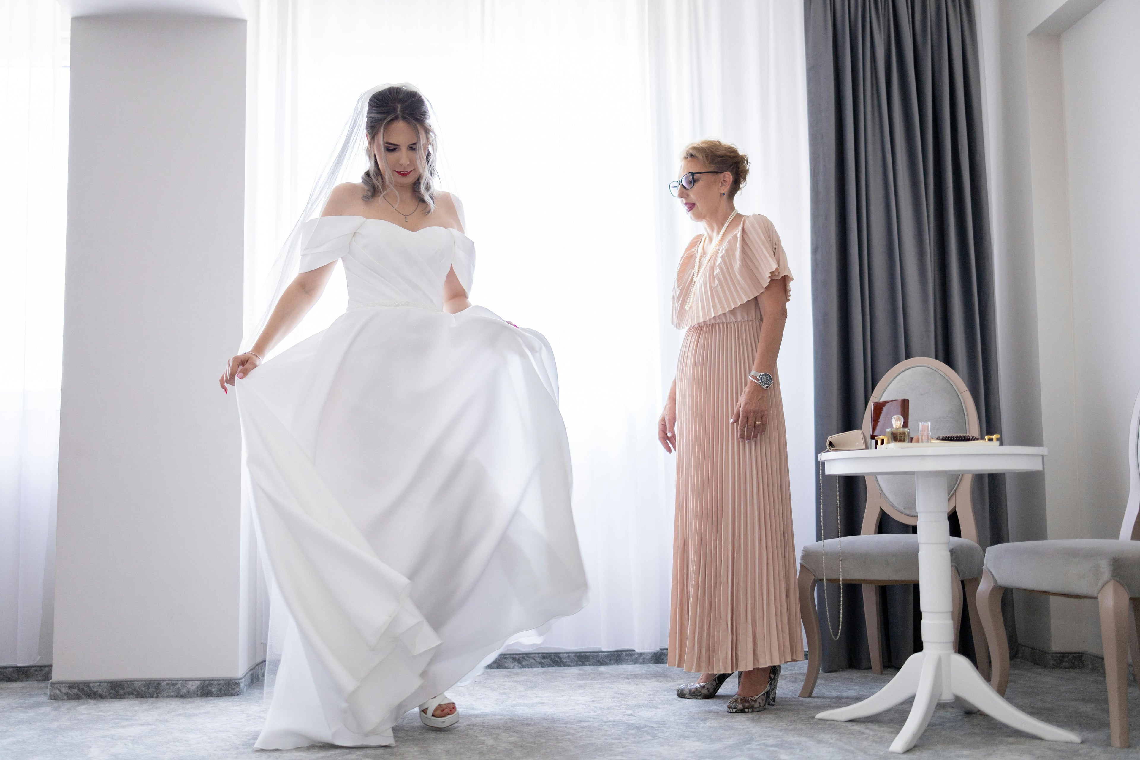 Bride twirling in her wedding dress in front of mum