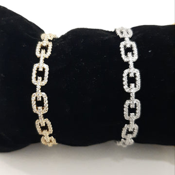 Two chain-link bracelets on a black cushion with a white background